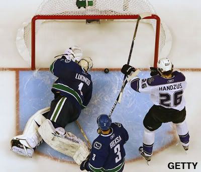 Michal Handzus #26 of the Los Angeles Kings and Kevin Bieksa #3 look on as Roberto Luongo #1 of the Vancouver Canucks makes a goal line save during overtime in Game One of the Western Conference Quarterfinals during the 2010 Stanley Cup Playoffs at General Motors Place on April 15, 2010 in Vancouver, British Columbia, Canada. Vancouver won 3-2. (Photo by Jeff Vinnick/NHLI via Getty Images)