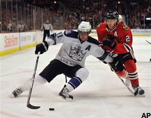 Los Angeles Kings' Anze Kopitar (11) fights for the puck with Chicago Blackhawks' Duncan Keith (2) during the first period of an NHL hockey game Sunday, Dec. 19, 2010, in Chicago. (AP Photo/Jim Prisching)