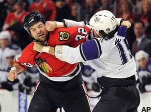 Chicago Blackhawks' John Scott (32) takes a punch from Los Angeles Kings' Kevin Westgarth (19) during the first period of an NHL hockey game Sunday, Dec. 19, 2010, in Chicago. (AP Photo/Jim Prisching)